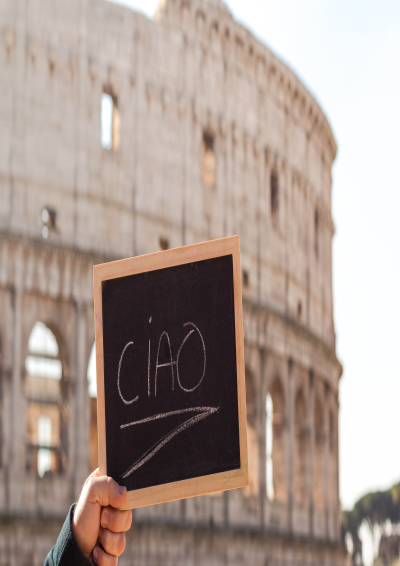 Colosseum i Rom og i forgrunden af billedet er en lille tavle hvor der står Ciao, som betyder hej på italiensk